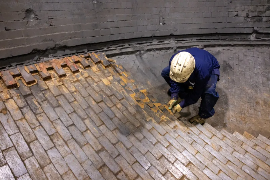 ovenbouwer plaatst vuurvaste steen